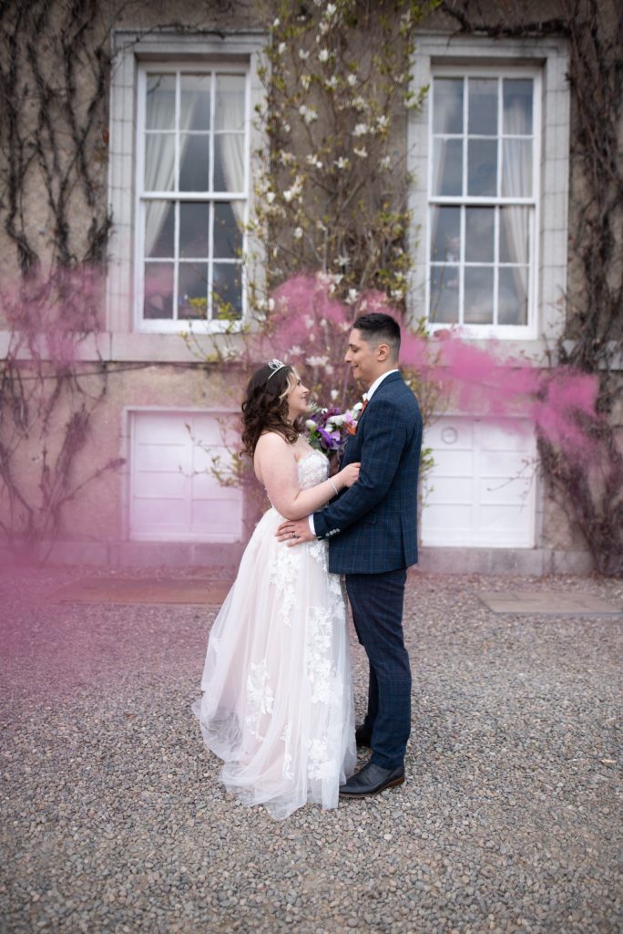 Bride and Groom with pink smoke outside Thainstone House - Aberdeen Wedding Photographer Blog photograph
